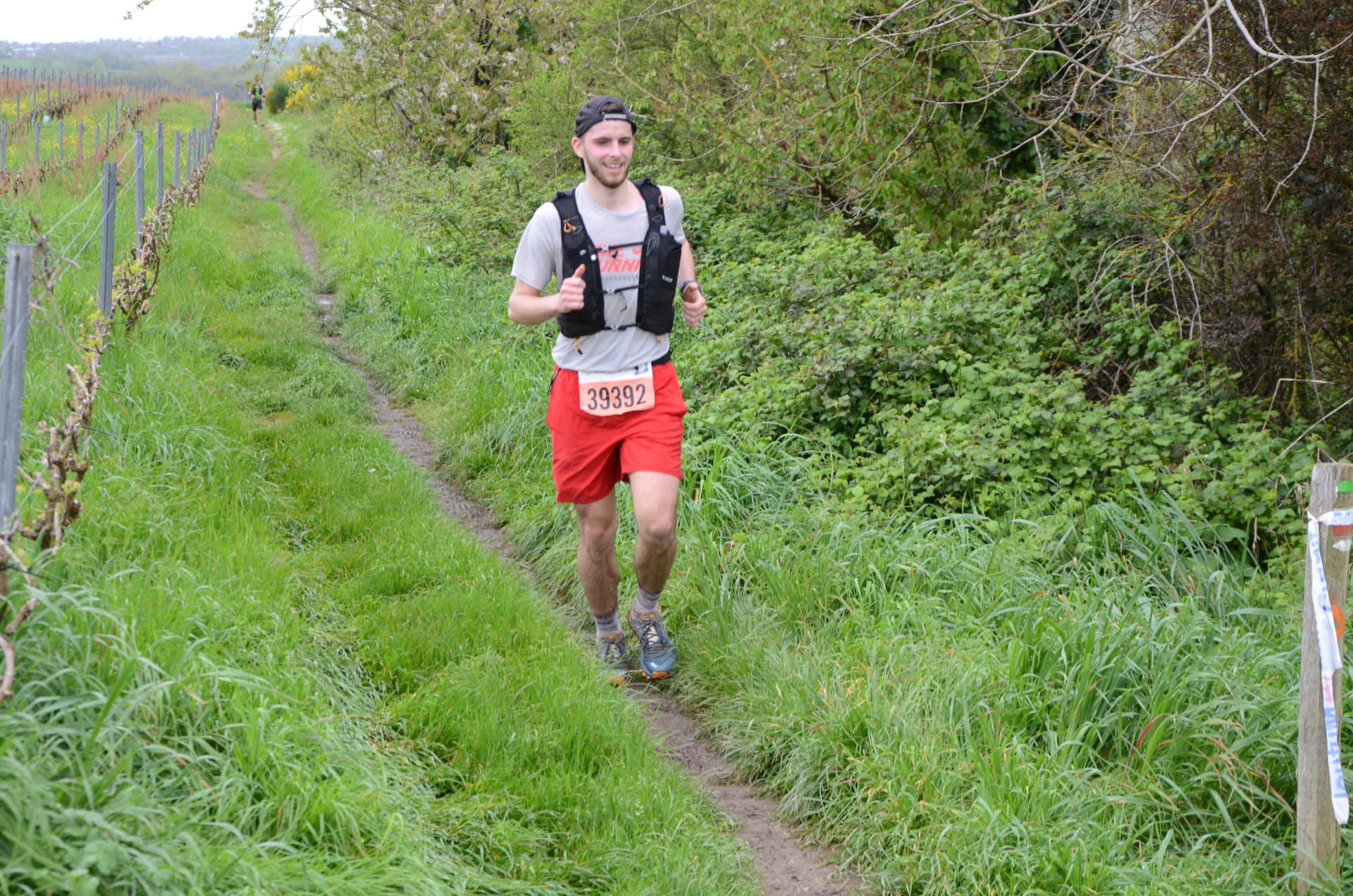 Marius en course sur un sentier de trail entre les vignes
